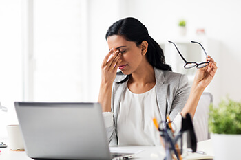 Woman suffering from Dry Eyes in the office