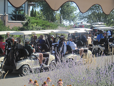 People lined up in golf carts