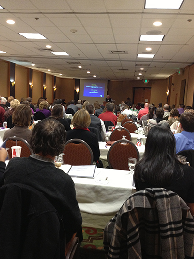 People sitting watching a presentation at the reimbursement course