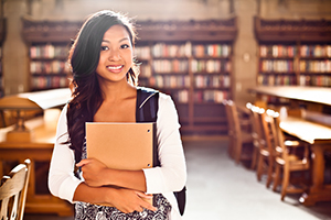 College student in a library holding a notebook