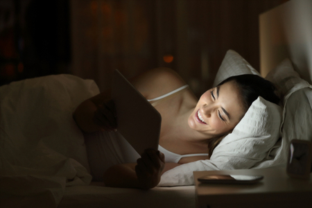 Woman Using Tablet in Bed