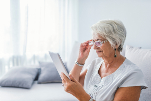 Older Woman with Glasses Attempting to Read