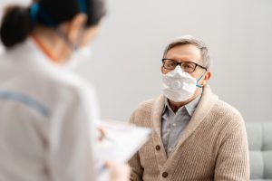 Patient meeting with their eye doctor, both wearing masks