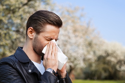 Man sneezing into a tissue